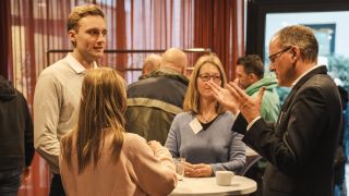 Gruppe diskutierender Gäste beim Politik-Info-Tag